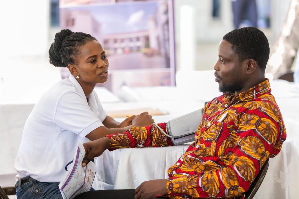 A health worker taking a patient's blood pressure