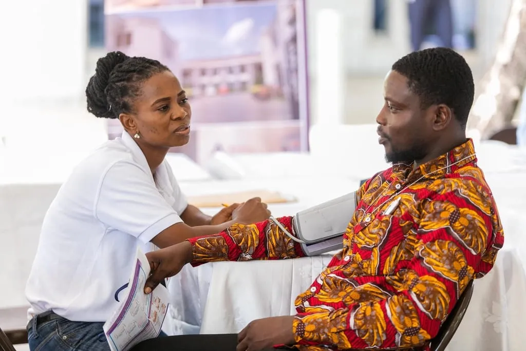 A health worker taking a patient's blood pressure