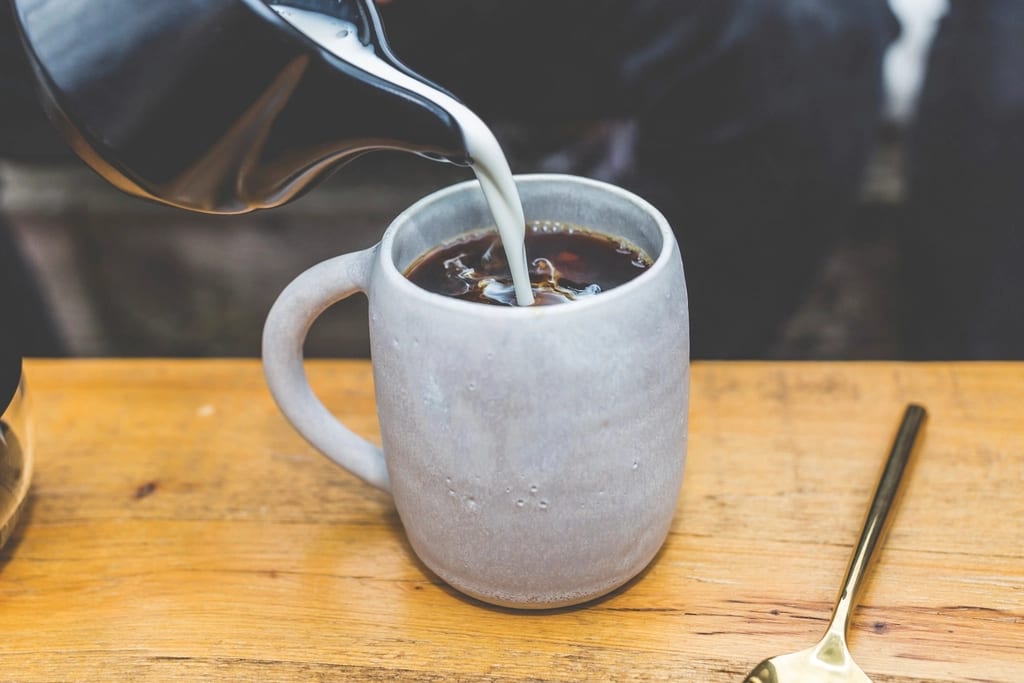 Milk being poured into a mug