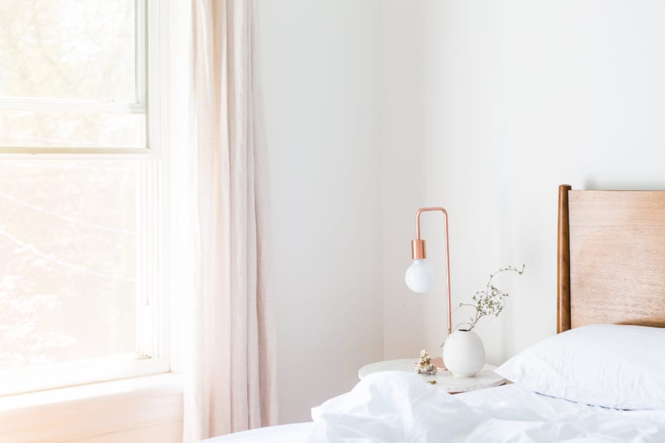 A bright bedroom with a made bed