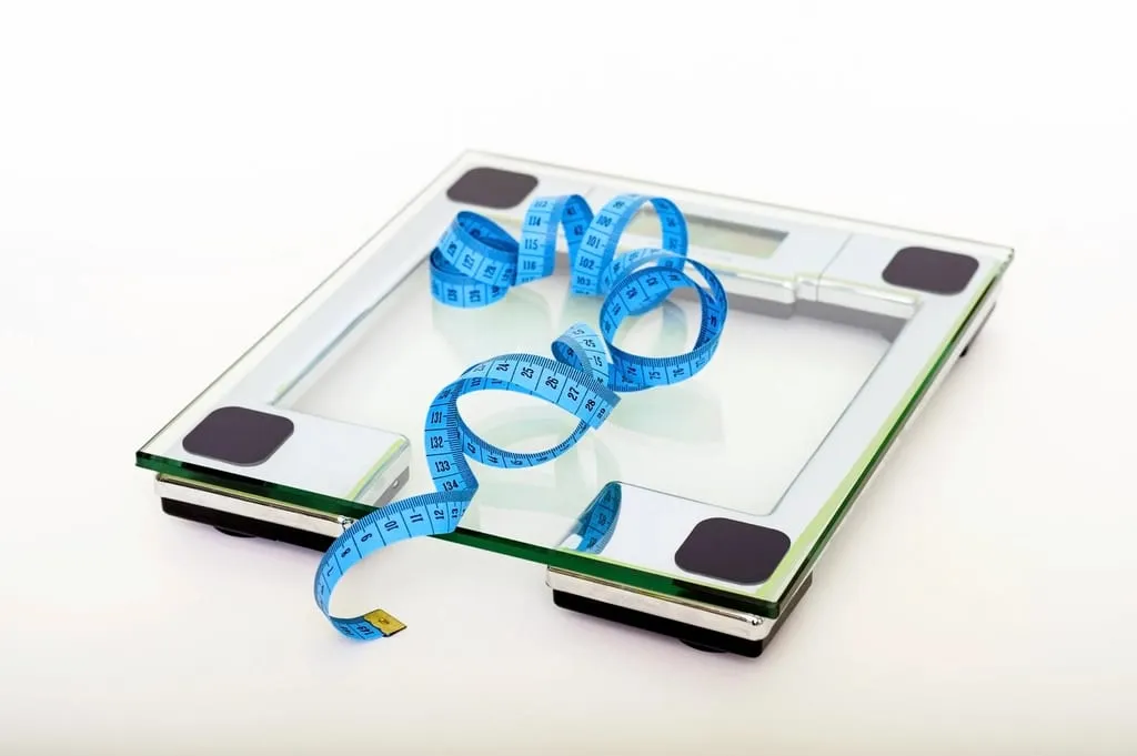 A bathroom scale and a measuring tape